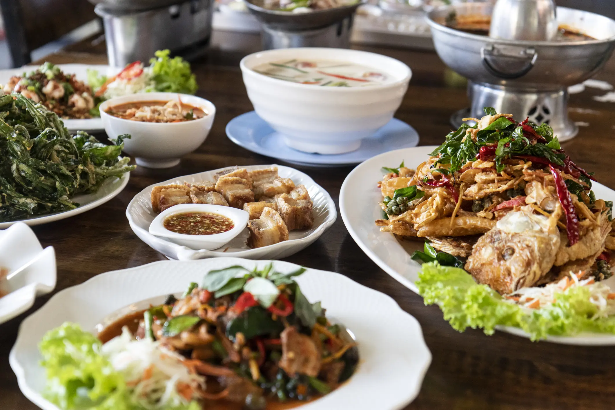 Assorted Thai dishes on a wooden table.