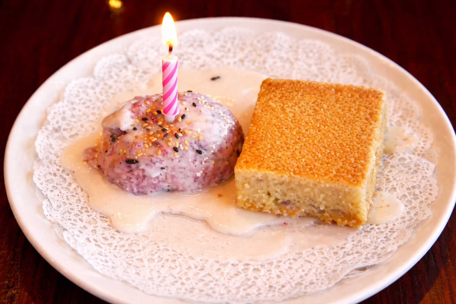 Cake with candle and dessert on plate.